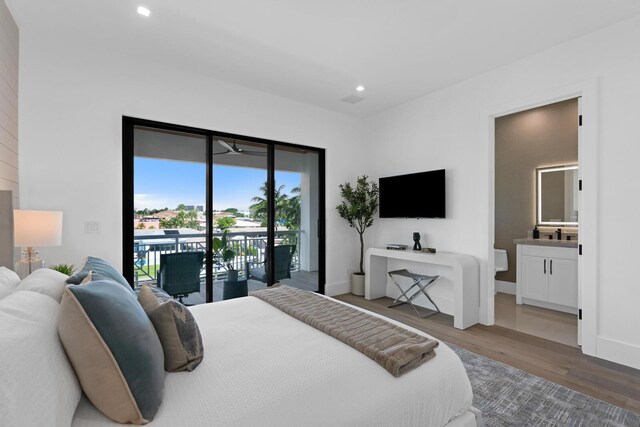 bedroom featuring hardwood / wood-style flooring, access to outside, and connected bathroom