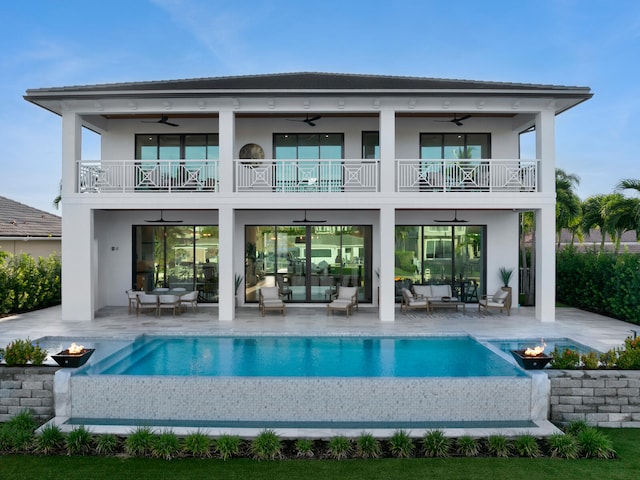 rear view of house featuring a patio area, ceiling fan, a balcony, and outdoor lounge area