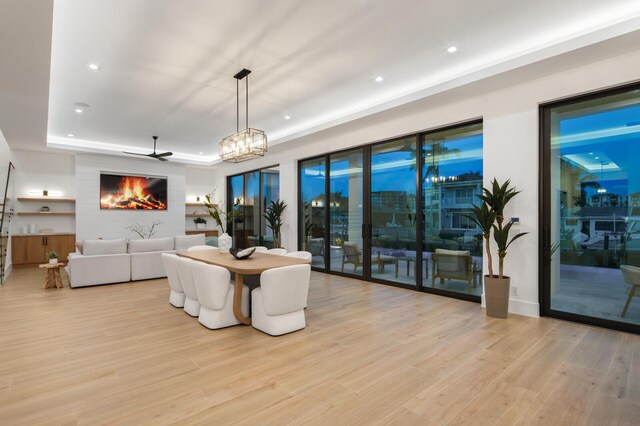 living room featuring a chandelier, a tray ceiling, and light hardwood / wood-style floors