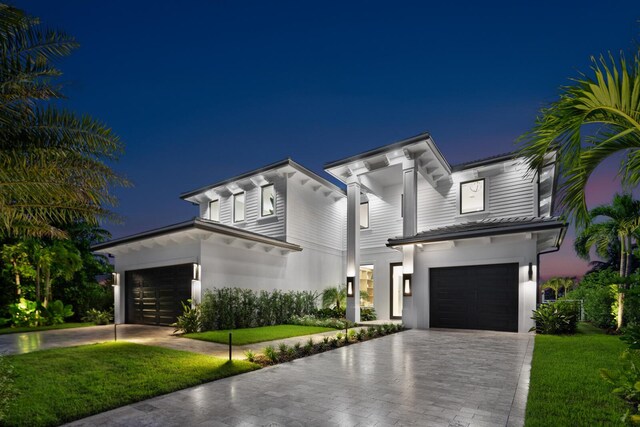 view of front of home with a garage and a yard