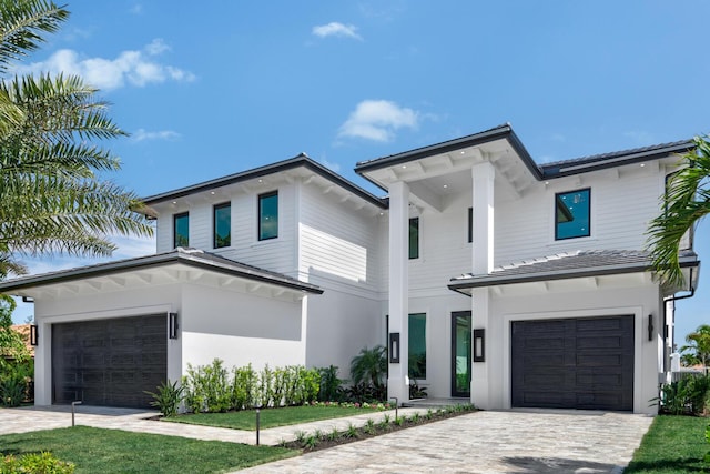 modern home with a garage and decorative driveway