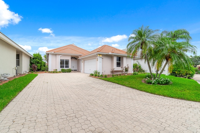 mediterranean / spanish house with a front yard and a garage