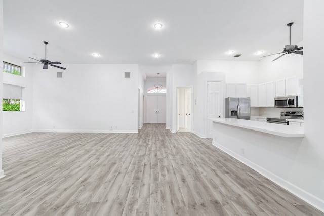 kitchen with light wood-type flooring, white cabinets, appliances with stainless steel finishes, and ceiling fan