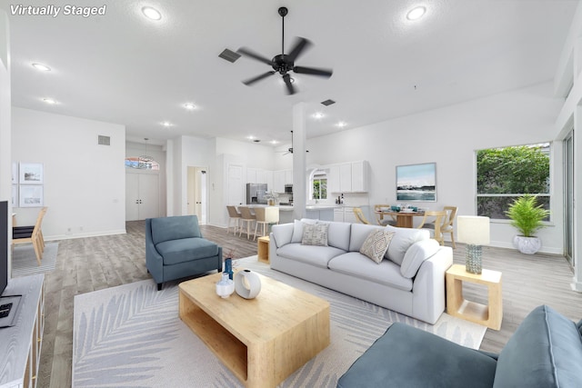 living room featuring ceiling fan and light hardwood / wood-style floors