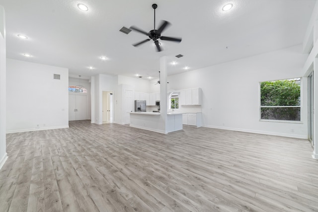 unfurnished living room with ceiling fan and light wood-type flooring