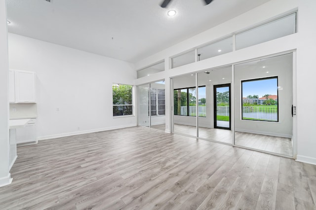 unfurnished living room featuring light wood-type flooring and ceiling fan