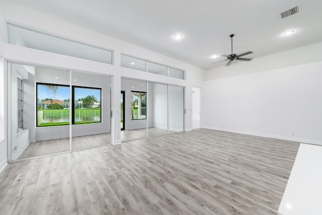 interior space with a water view, ceiling fan, and light hardwood / wood-style flooring