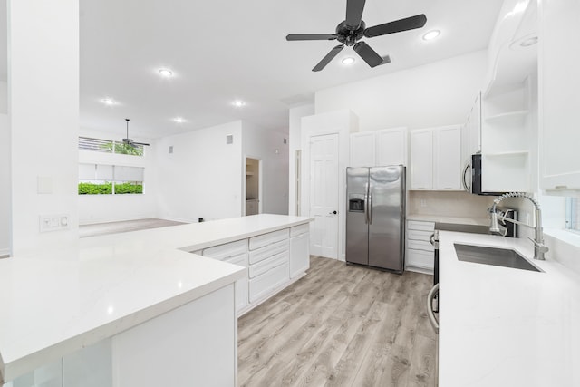 kitchen with light hardwood / wood-style flooring, appliances with stainless steel finishes, sink, ceiling fan, and white cabinets