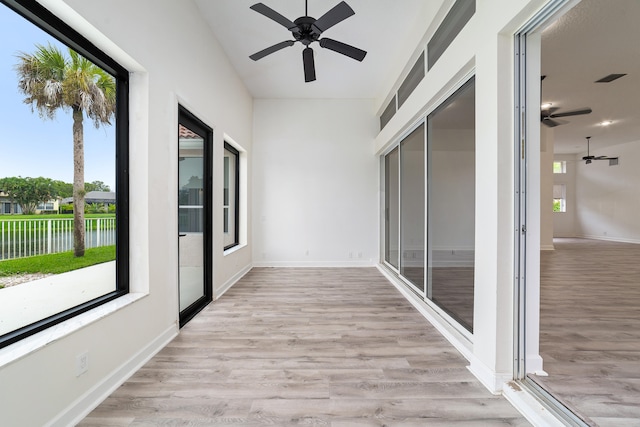 unfurnished sunroom with ceiling fan