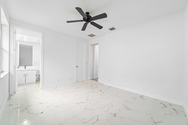 unfurnished bedroom featuring ceiling fan, sink, a closet, and connected bathroom