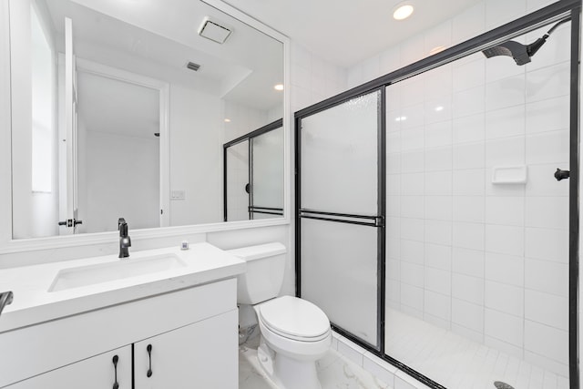 bathroom featuring toilet, a shower with door, and vanity