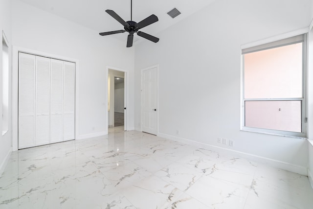 unfurnished bedroom featuring multiple windows, ceiling fan, and a closet