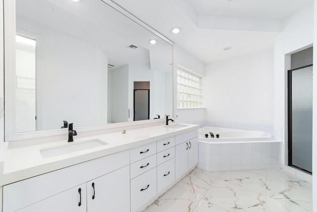 bathroom featuring vanity and independent shower and bath