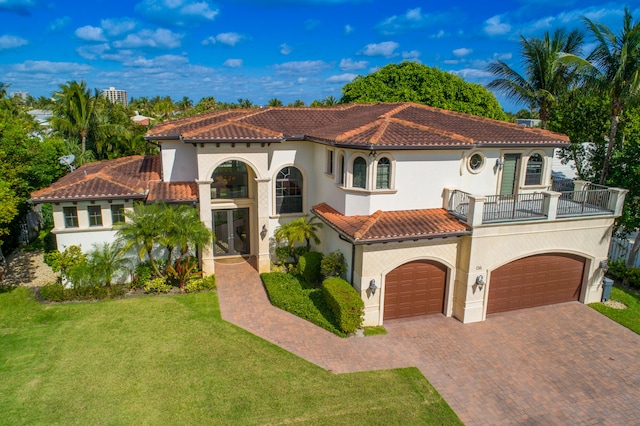 mediterranean / spanish home with a balcony, a garage, and a front yard