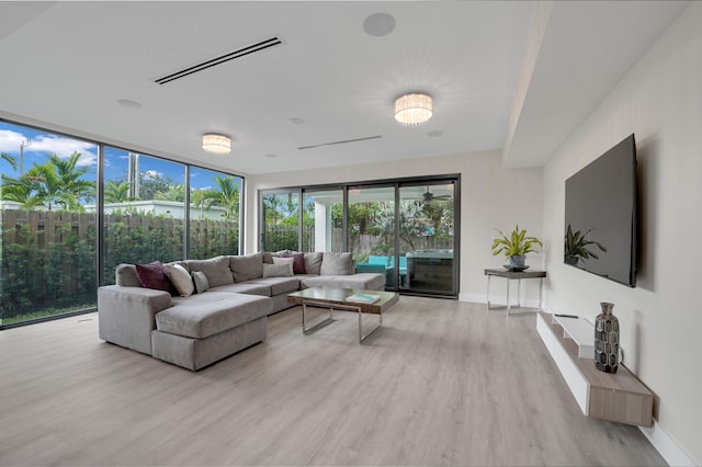 living room featuring a wall of windows and light hardwood / wood-style floors