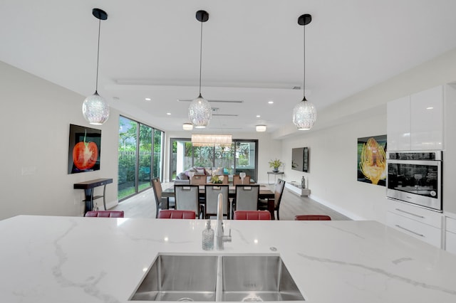 kitchen featuring a healthy amount of sunlight, pendant lighting, and oven