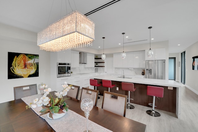 dining area with sink and light hardwood / wood-style floors