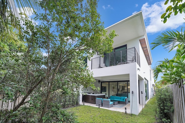 rear view of house featuring a lawn, a patio, an outdoor hangout area, and a balcony