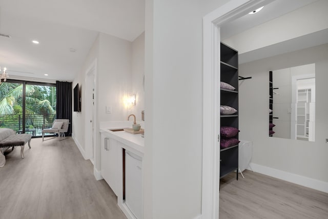 hall with light hardwood / wood-style flooring and sink