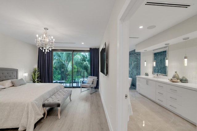 bedroom featuring light wood-type flooring, ensuite bathroom, and sink