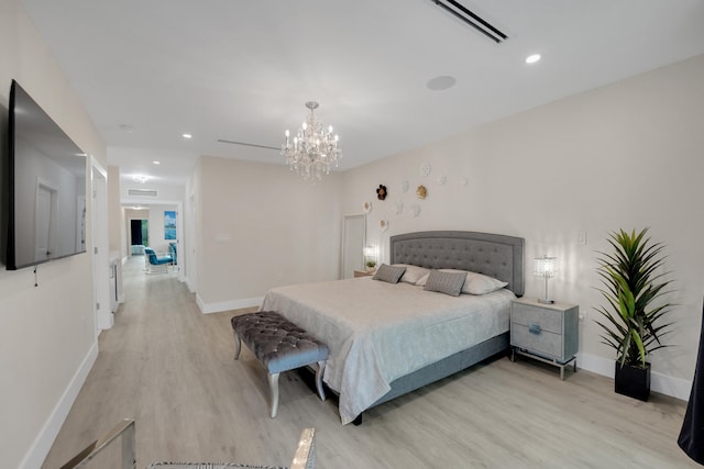 bedroom with light wood-type flooring and an inviting chandelier