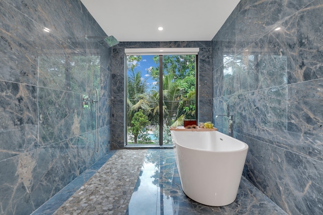 bathroom with tile walls and independent shower and bath