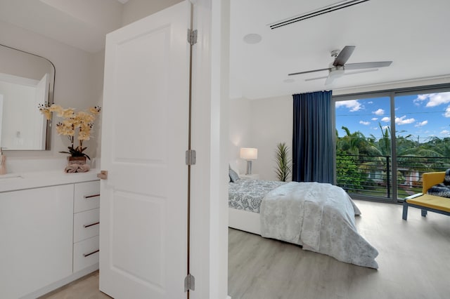 bedroom with light hardwood / wood-style floors, floor to ceiling windows, ceiling fan, and access to outside