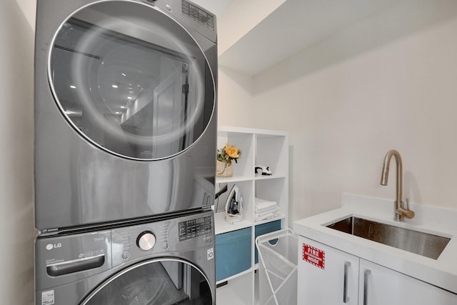 laundry room featuring stacked washer / dryer, cabinets, and sink