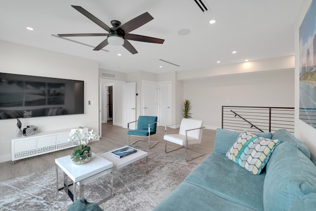 living room featuring wood-type flooring and ceiling fan