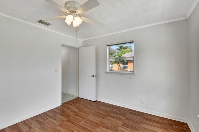 empty room featuring ornamental molding, hardwood / wood-style floors, and ceiling fan