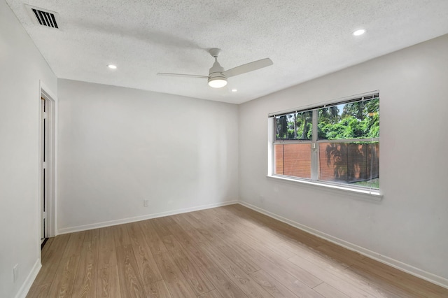 empty room with a textured ceiling, light hardwood / wood-style floors, and ceiling fan