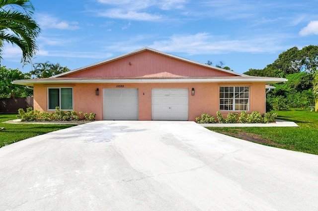 back of house with a garage and a lawn