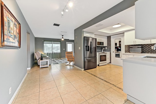 kitchen featuring backsplash, ceiling fan, white cabinets, and stainless steel appliances