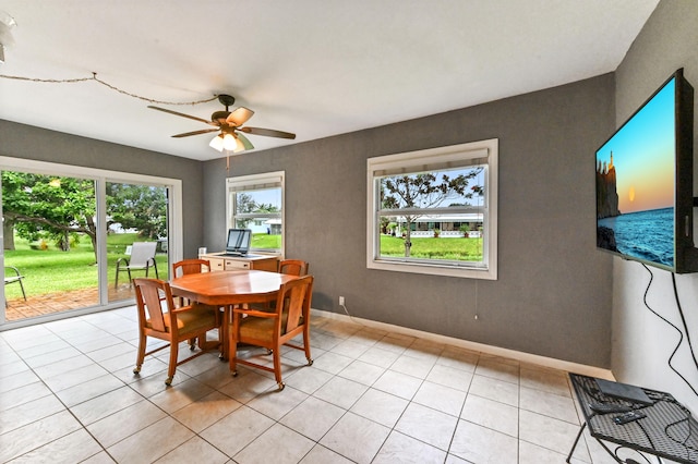 tiled dining space with ceiling fan and a healthy amount of sunlight