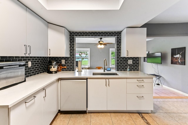 kitchen with white cabinets, decorative backsplash, ceiling fan, and sink