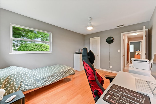 bedroom with ceiling fan, a closet, and hardwood / wood-style flooring