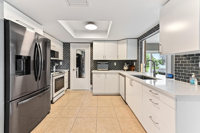 kitchen featuring white cabinets, backsplash, sink, and appliances with stainless steel finishes