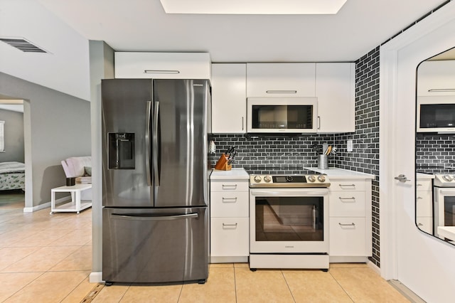 kitchen featuring white cabinets, white appliances, light tile patterned floors, and tasteful backsplash