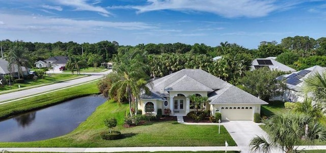 view of front of home with a water view, a garage, concrete driveway, and a front yard