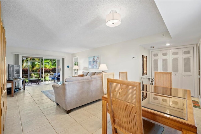 living room featuring light tile patterned flooring and a textured ceiling