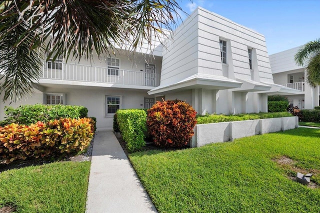 view of front facade with a front yard and stucco siding