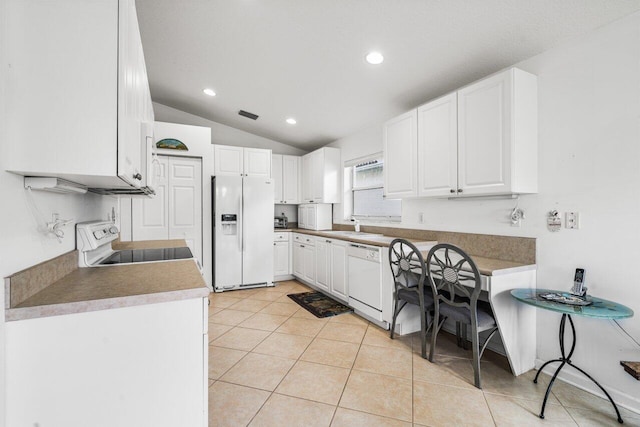 kitchen with white cabinets, white appliances, sink, vaulted ceiling, and light tile patterned flooring