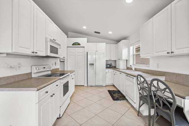 kitchen with white cabinets, white appliances, light tile patterned flooring, and vaulted ceiling