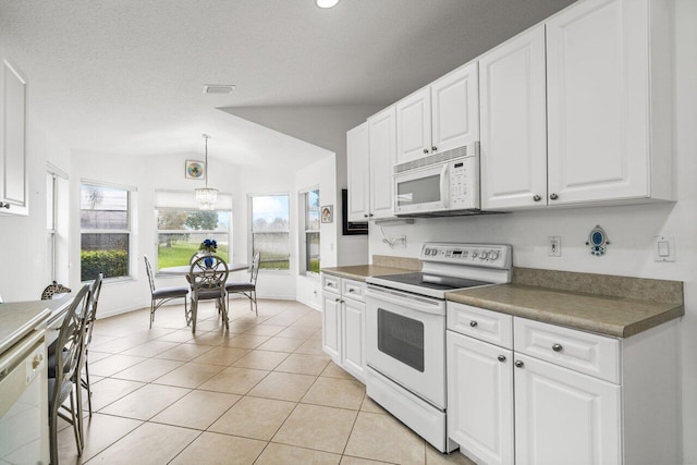 kitchen with lofted ceiling, decorative light fixtures, white appliances, and white cabinetry