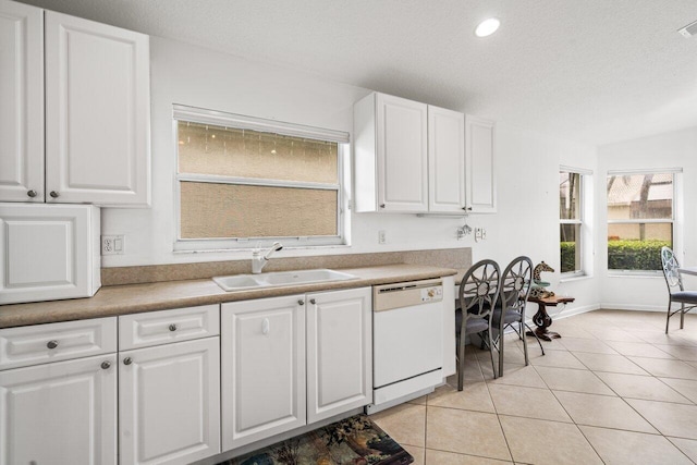 kitchen featuring white dishwasher, sink, and white cabinetry