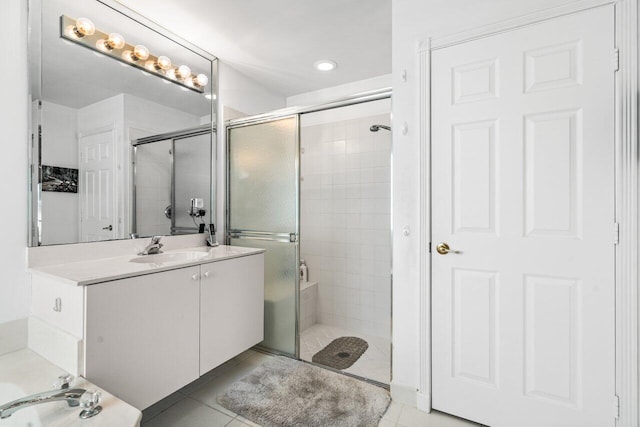 bathroom with a shower with shower door, tile patterned flooring, and vanity