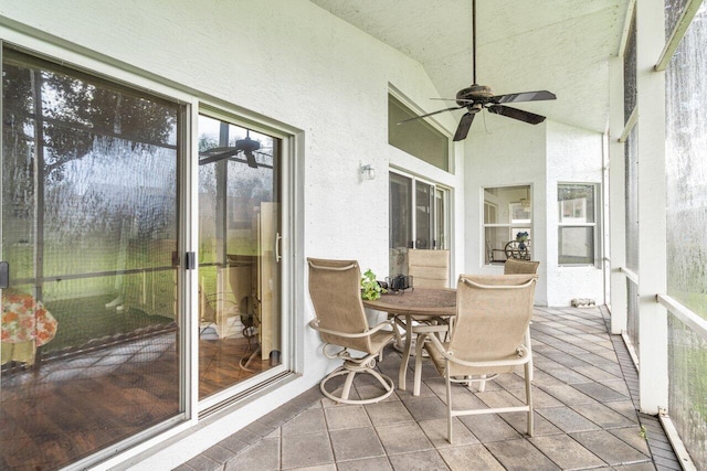 sunroom with ceiling fan and vaulted ceiling