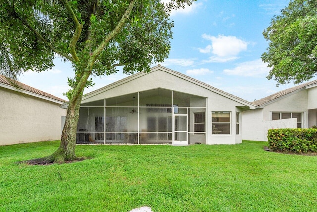 rear view of property with a sunroom and a lawn