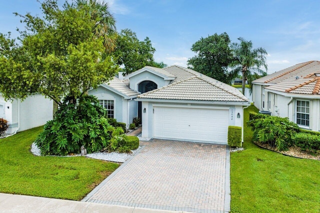 view of front of property with a garage and a front lawn