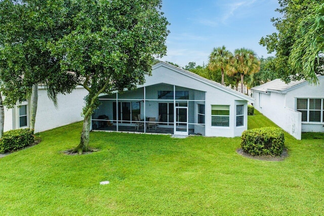 back of property with a sunroom and a yard